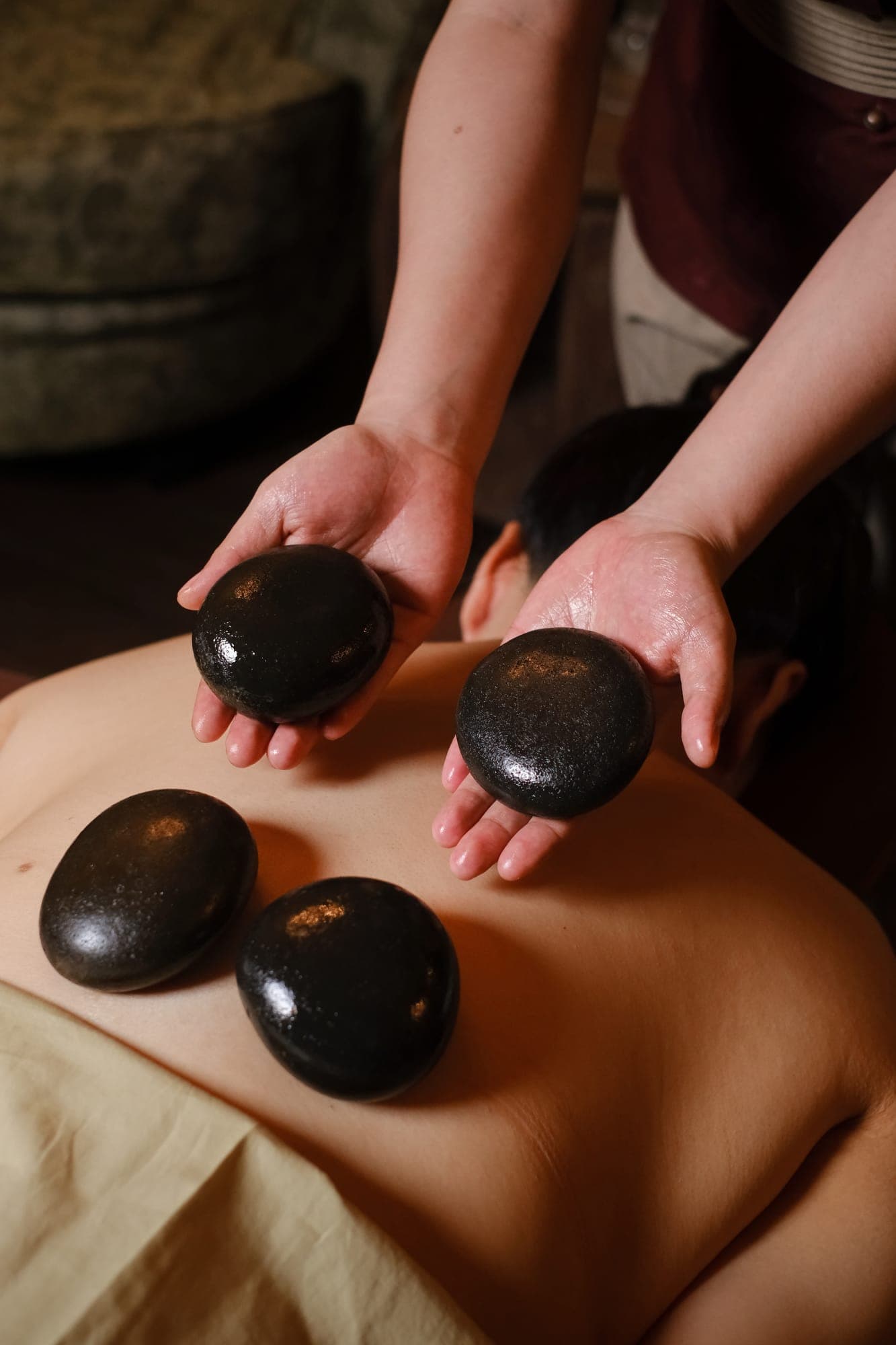 A therapist placing warm stones on a guest's back