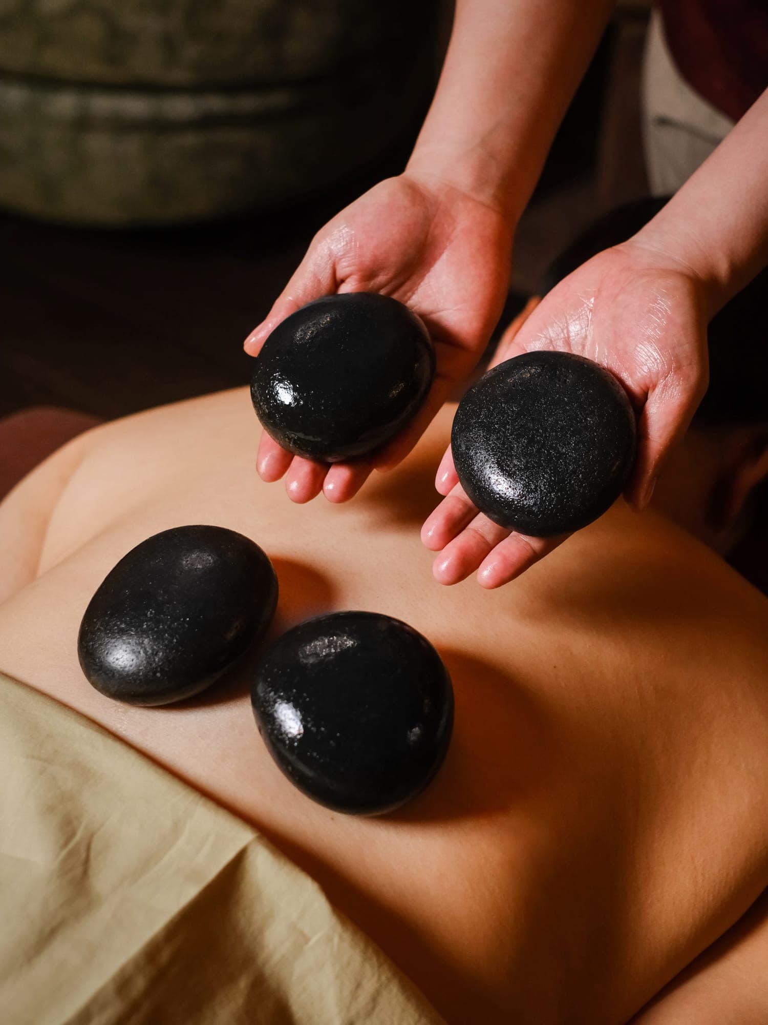 A therapist placing warm stones on a guest's back