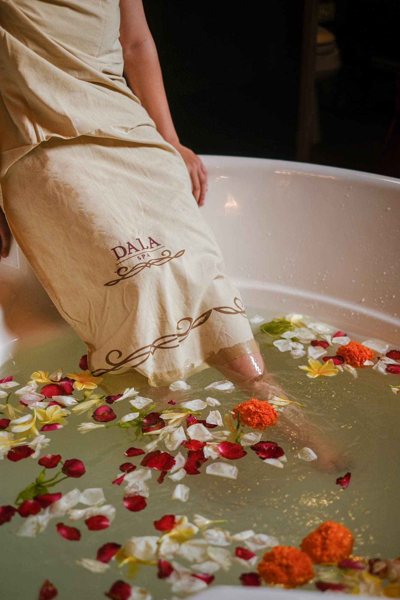 A guest dipping into a petal bath