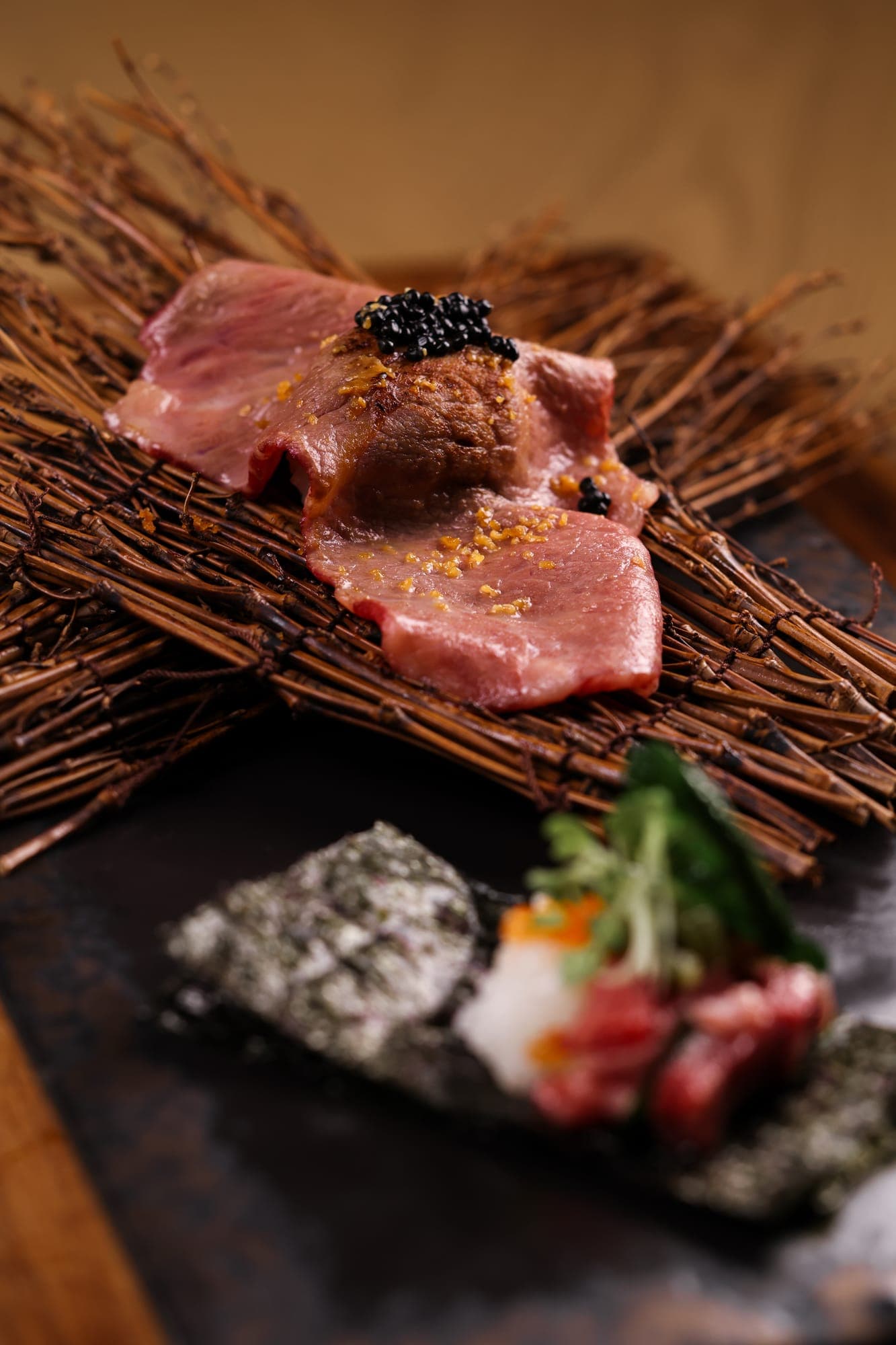 Seared wagyu topped with caviar on a bed of twigs at Honzen