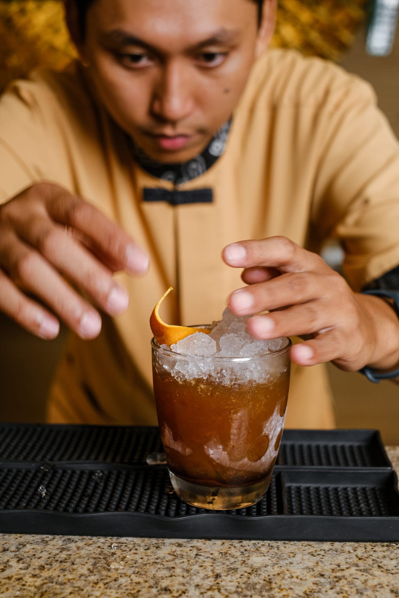 A bartender garnishing a cocktail