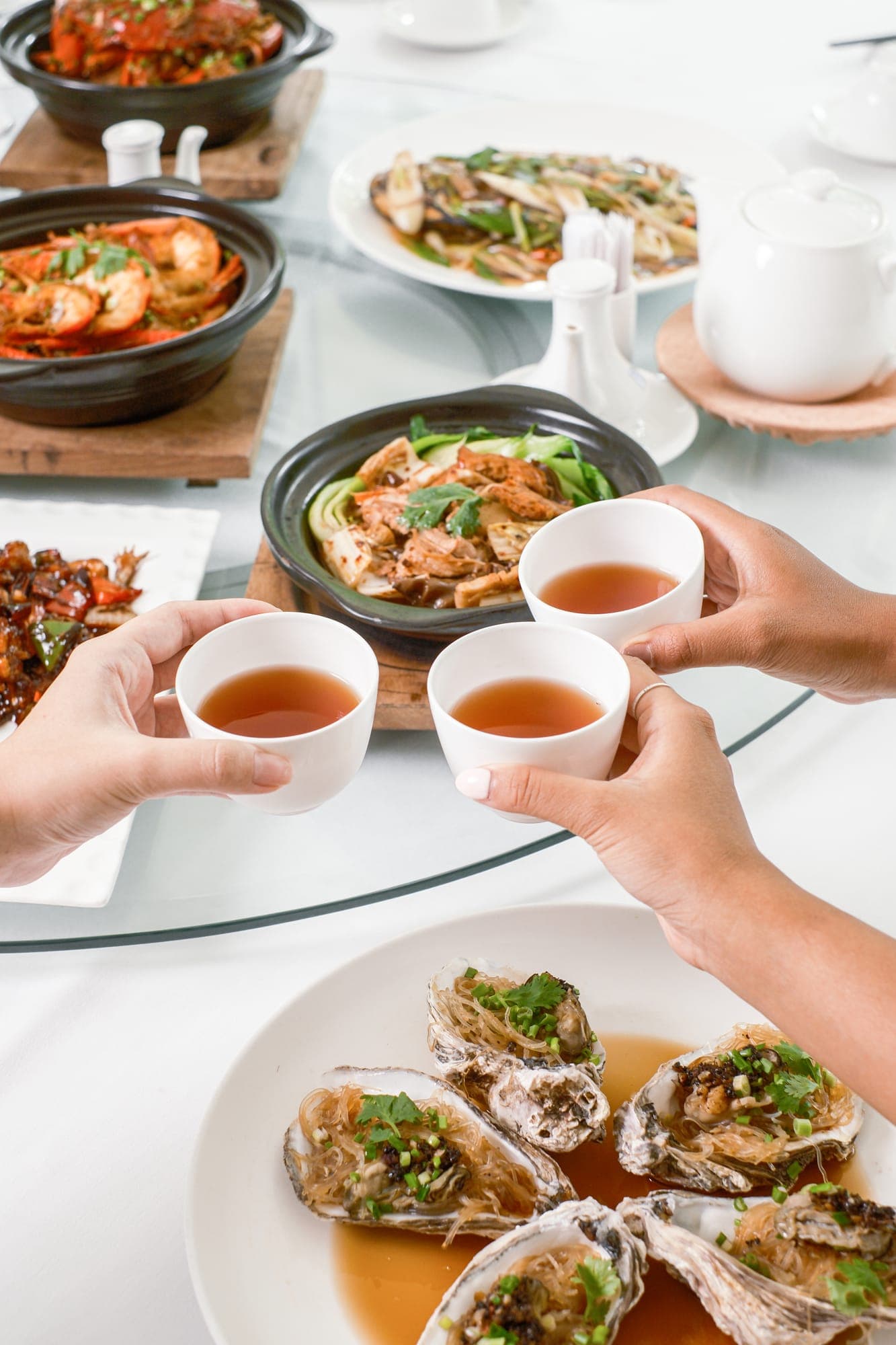 Guests raising teacups over a shared meal