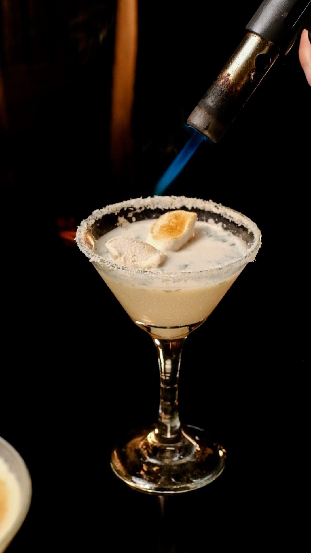 A cocktail being torched at the bar