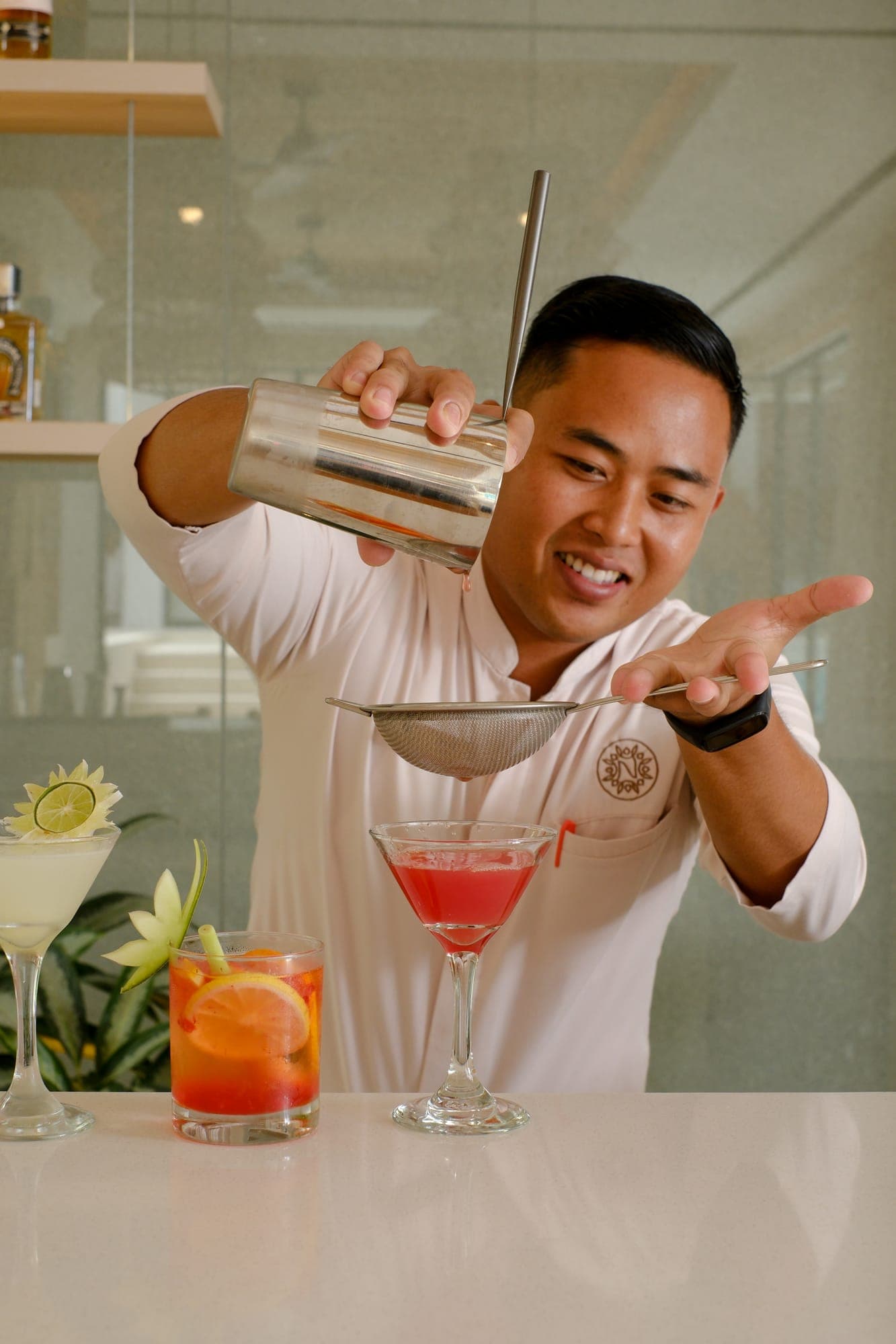 A bartender pouring from a cocktail shaker
