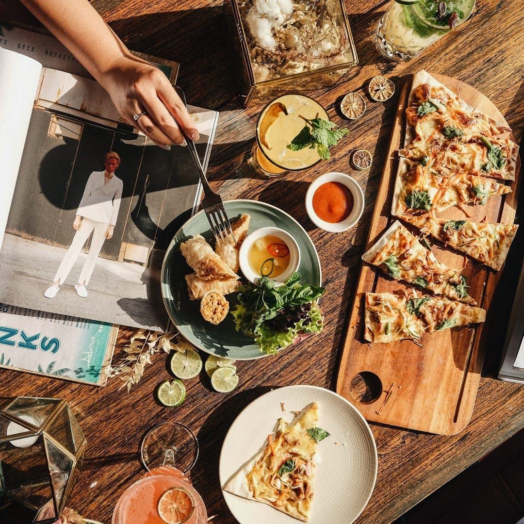 A table of flatbreads and small plates, seen from above