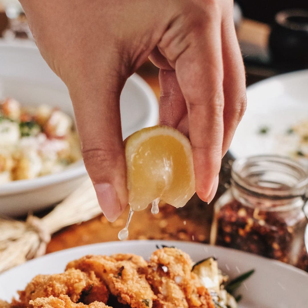 Lemon squeezed over a plate of fried calamari